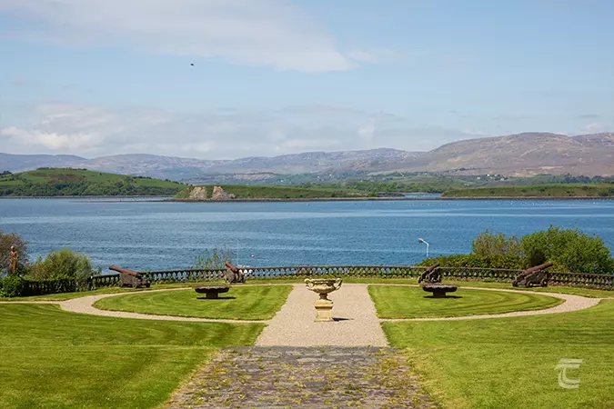 A circular landscaped garden overlooks Bantry Bay with Whiddy Island in the distance