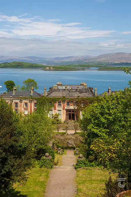 Aerial view of Bantry House with the blue water of Bantry Bay in the background