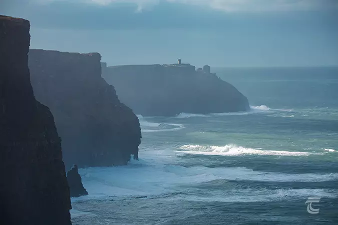 Waves crash into the rocks at the foot of the Cliffs of Moher on the Wild Atlantic Way