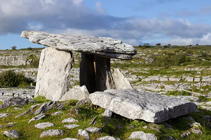 The slanted capstone of the dolmen supported by portal stones