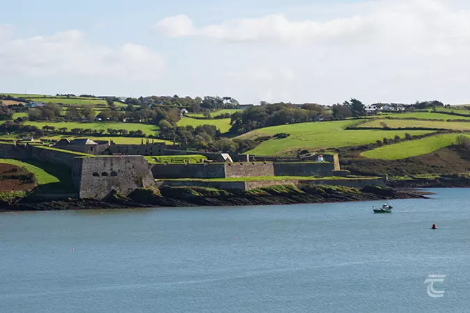 Looking toward Charles Fort from Kinsale Harbour. The grey walls of the fort amongst sloping green fields.
