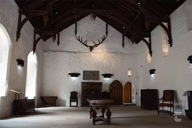 Interior of the Great Hall, Cahir Castle, Tipperary. The walls are whitewashed, and there's an immense stag skull and antlers mounted to the walls.