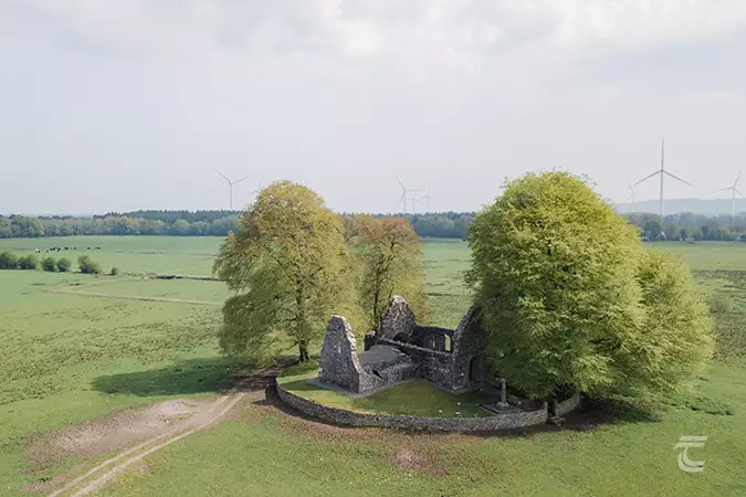 Aerial view of Monaincha Abbey, Tipperary, with large (modern) windmills in the background