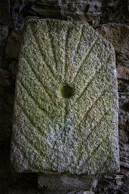 A decorated stone slab with hollow in the centre