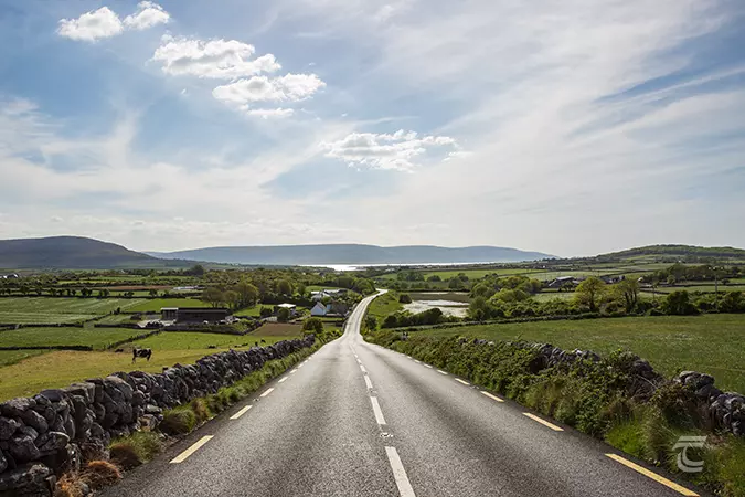 A road cuts through countryside heading toward Galway Bay